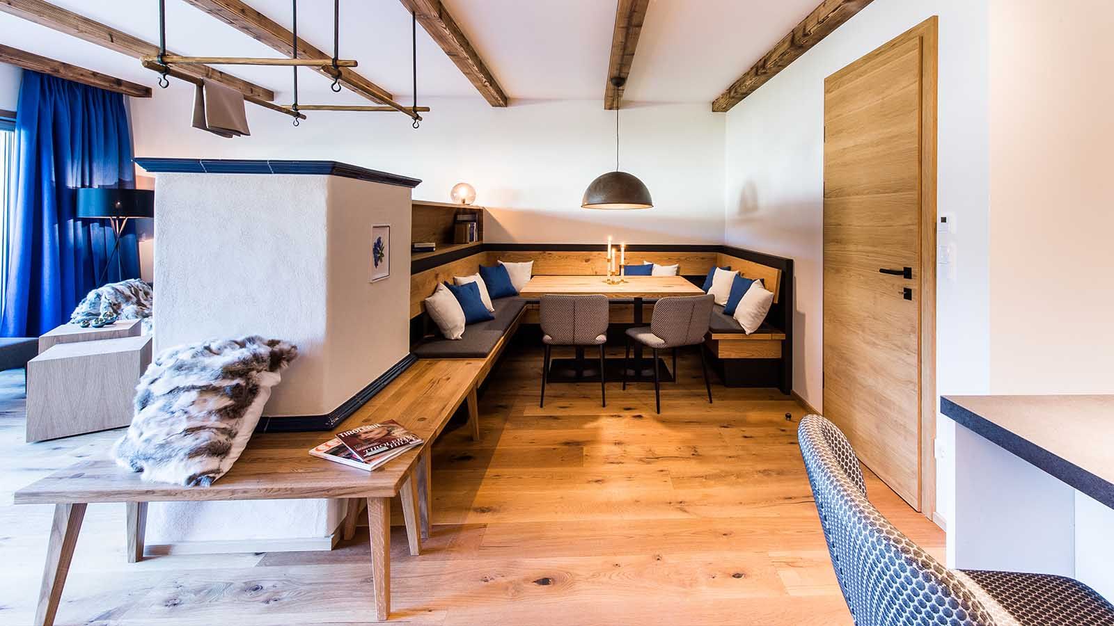 Sitzecke aus Holz mit weißer Ofenrückwand als Gastronomiekonzept